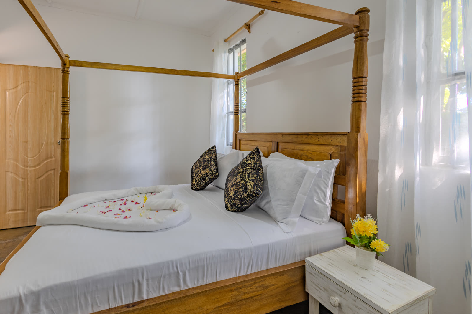 Bedroom with a made-up bed and bedside table in the two-bedroom villa
